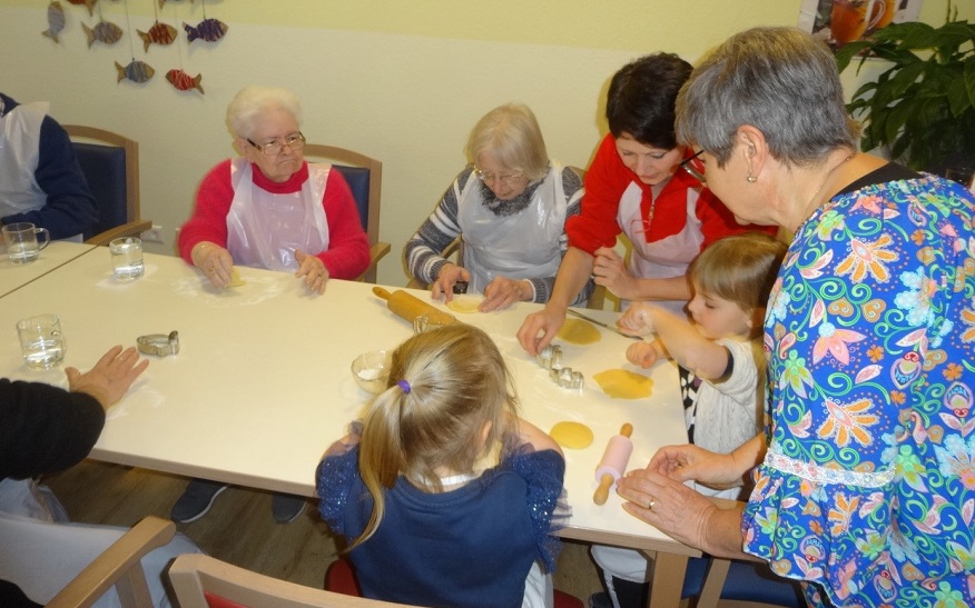 Die Kinder der Kita Kirchstraße backen gemeinsam mit den Seniorinnen und Senioren in der Kirchlichen Sozialstation Osterhasen.