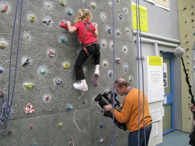 Kletterndes Mädchen mit Kameramann Kletterndes Mädchen mit Kameramann
